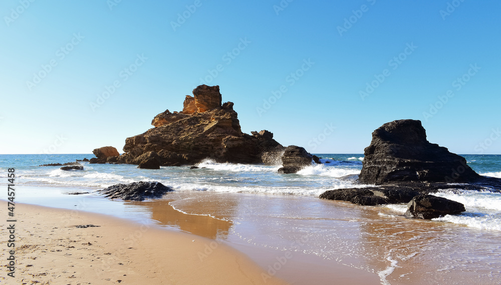 Waves crashing on rocks and rolling on the beach