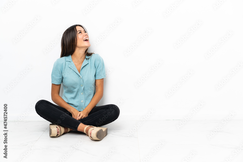 Teenager girl sitting on the floor laughing in lateral position Teenager girl sitting on the floor laughing in lateral position
