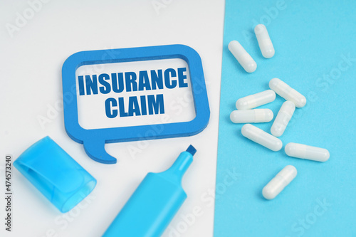On the white and blue surface are a marker, tablets and a plate inside which the inscription - Insurance Claim