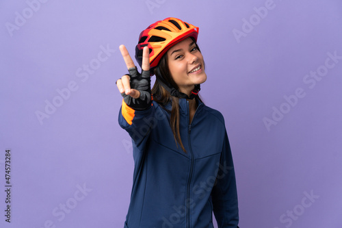 Teenager cyclist girl smiling and showing victory sign © luismolinero