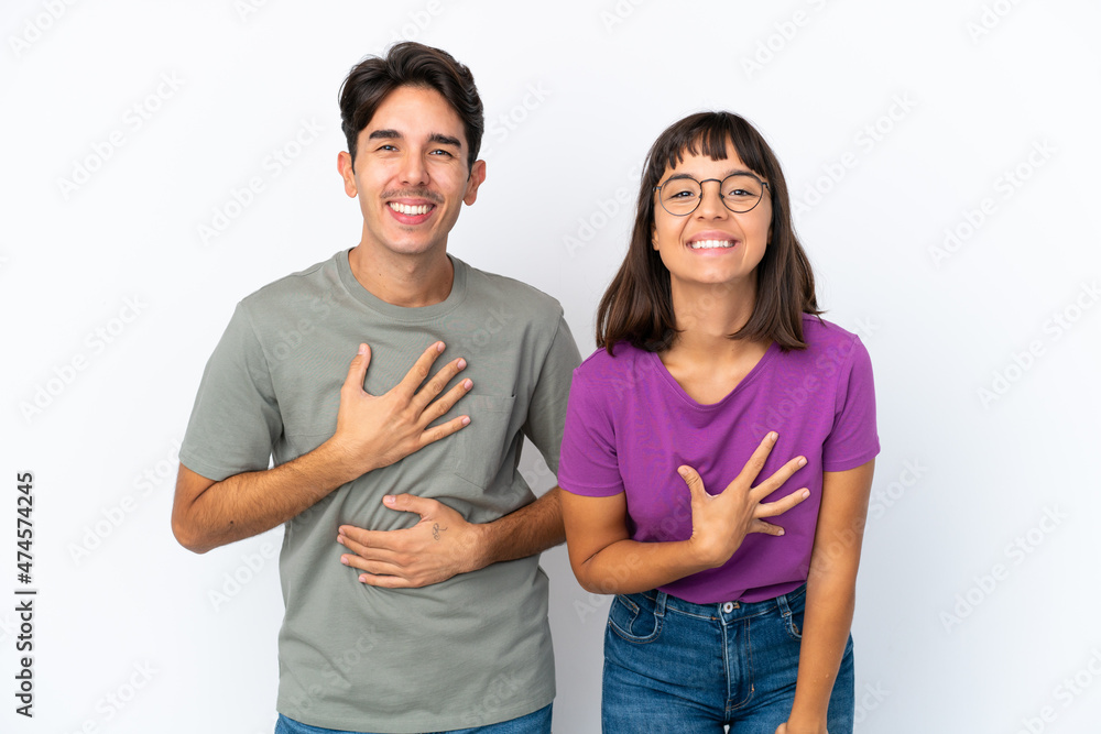 Young couple isolated on isolated white background smiling a lot while putting hands on chest Young couple isolated on isolated white background smiling a lot while putting hands on chest