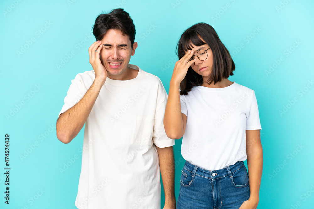 Young mixed race couple isolated on blue background unhappy and frustrated with something