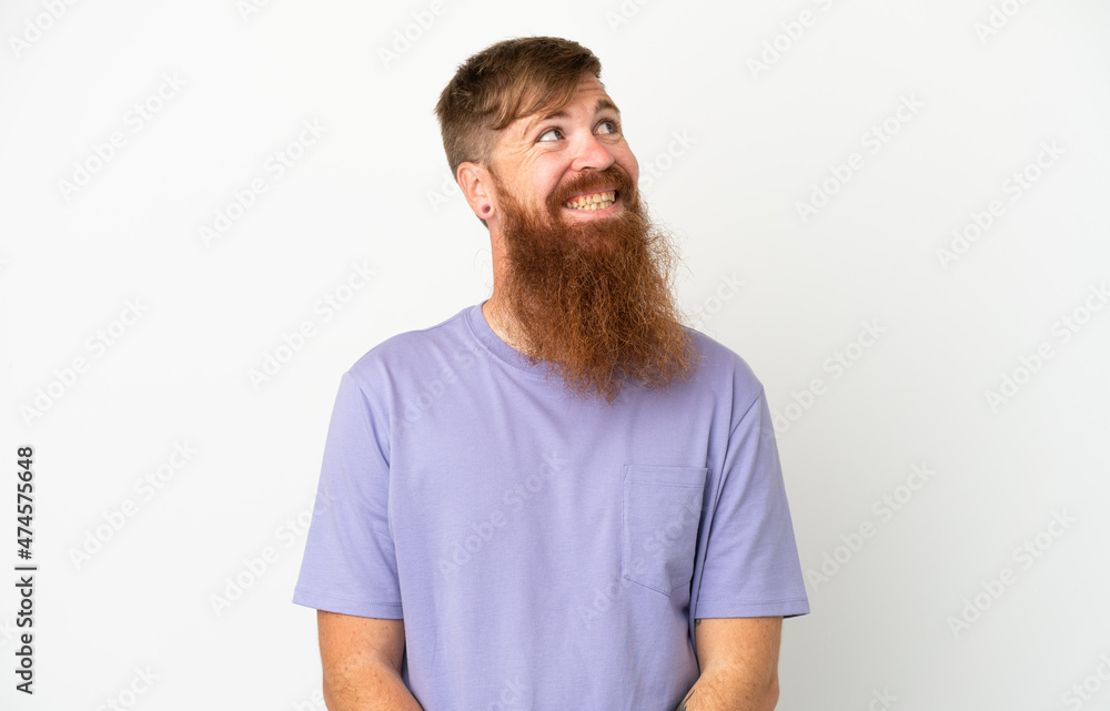 Young reddish caucasian man isolated on white background thinking an idea while looking up