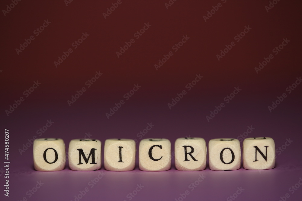 Word OMICRON on purple table close up Word OMICRON on purple table close up