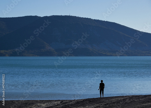 hombre paseando por la orilla de un pantano  se ve su silueta gracias a la especial luz del atardecer