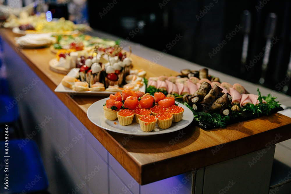 Meal. Festive buffet table for guests. Assortment of cold cuts,canapes on wooden skewers, festive snacks with fruits and salads. Reception at the party. Meal. Festive buffet table for guests. Assortment of cold cuts,canapes on wooden skewers, festive snacks with fruits and salads. Reception at the party.