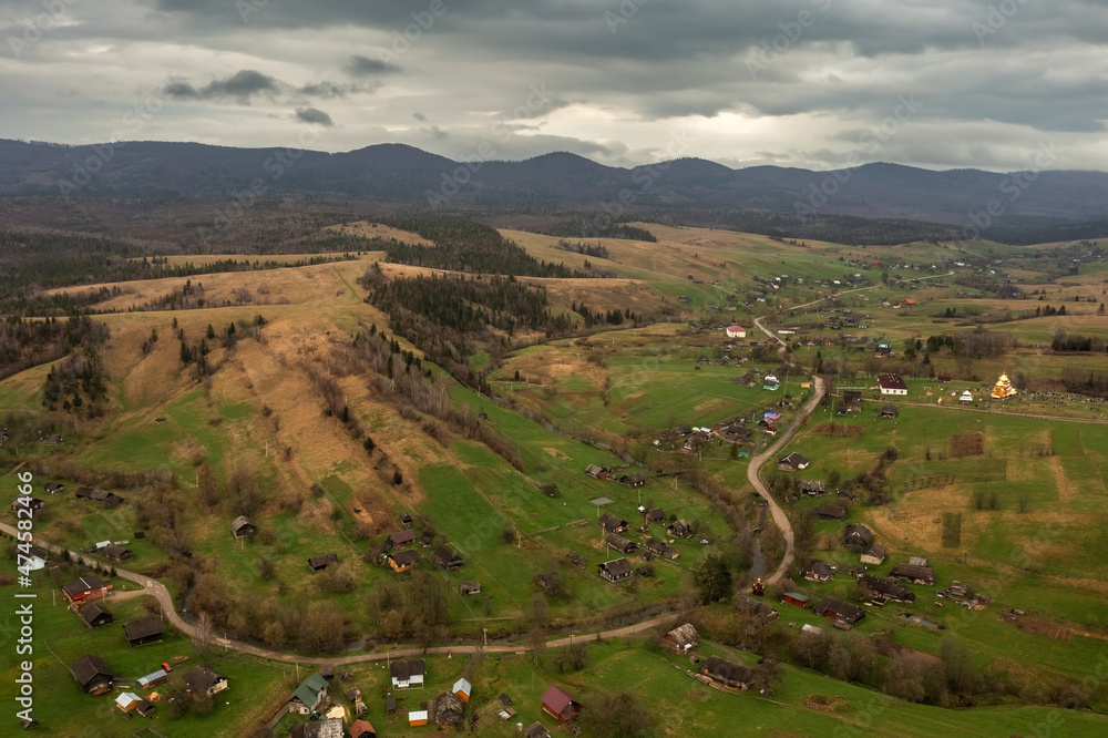 Aerial view of a narrow winding road through the beautiful wooded Carpathians, amazing spring landscape, outdoor tourist background, Transcarpathia, Ukraine