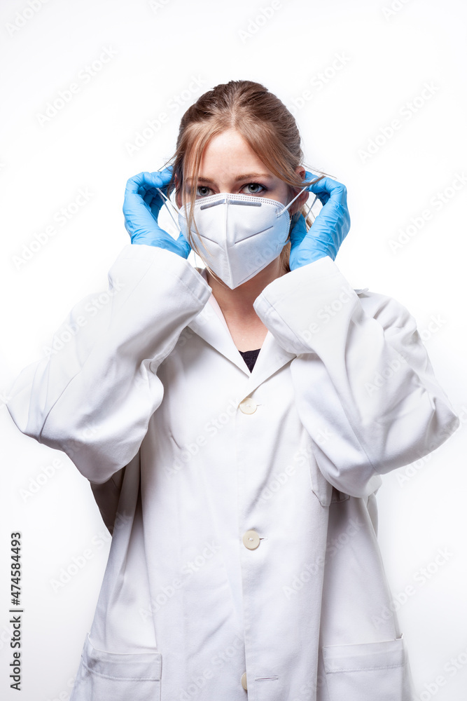 studio shot on white background of a young female doctor adjusting a face mask studio shot on white background of a young female doctor adjusting a face mask