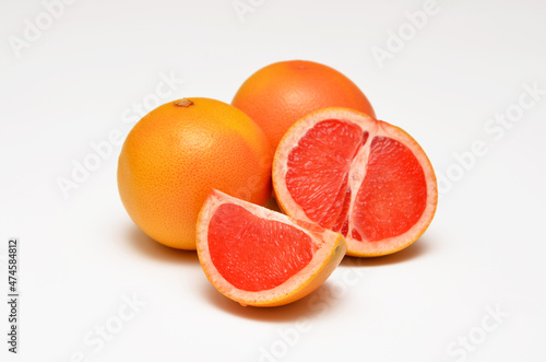 whole and cut grapefruits close-up on a white background