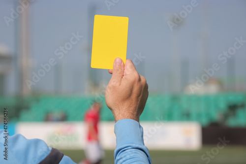 Football referee shows a yellow card. 