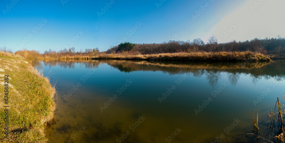Fototapeta premium Panoramic view of a calm lake on a sunny summer day