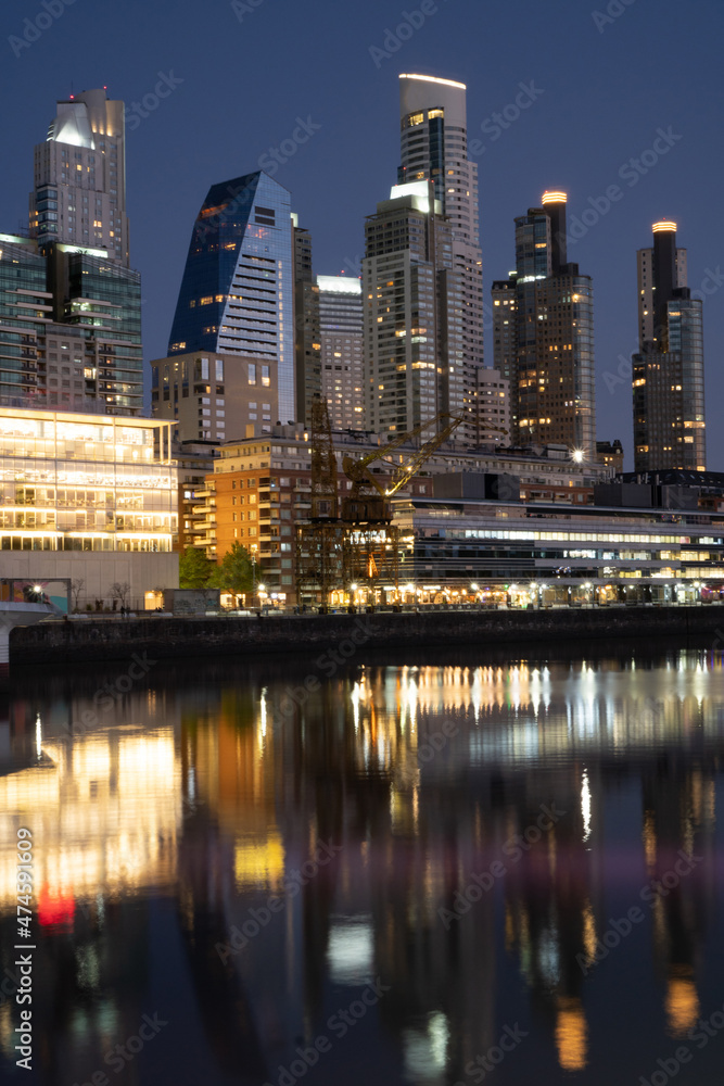 Puerto Madero, Buenos Aires buildings reflected in the water, night in a luxurious neighborhood. vertical picture
