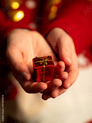 dawać prezent - dłonie trzymające mały czerwony prezent, prezent świąteczny, święta bożego narodzenia