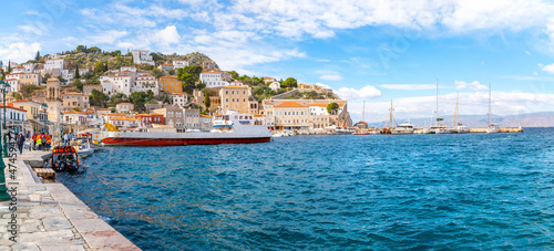 The small harbor and port at the Greek island of Hydra, Greece, with shops, cafes and boats in the sea.