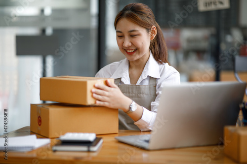 Portrait of Starting small young businesses SME owners female entrepreneurs working on receipt box and check online orders to prepare to pack the boxes, sell to customers, SME business ideas online.