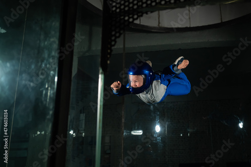 A man teaches a boy to fly in a wind tunnel.