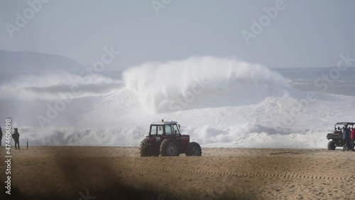 Slow motion of a wave break on the beach in Nazaré, Portugal. Nazaré is a small village in Portugal with the biggest waves in the world. photo