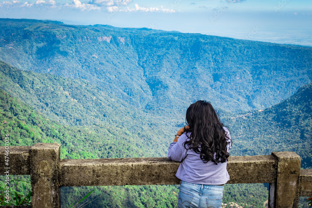 young girl watching the mountain range with bright blue sky at afternoon from flat angle