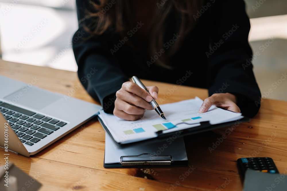 Close up financial adviser is reviewing report with charts and graphs, tax, budget, accounting concept Close up financial adviser is reviewing report with charts and graphs, tax, budget, accounting concept