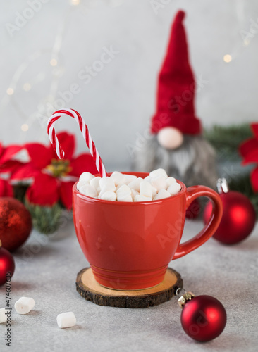  New Year card. Red cocoa mug with marshmallows, striped candy and Christmas tree decorations.