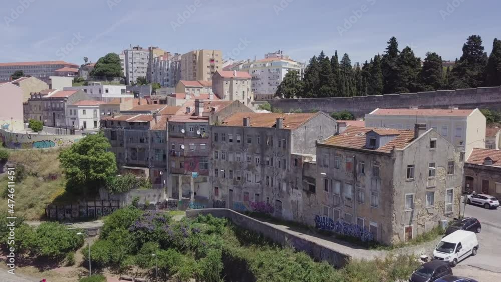 Drone aerial shot of run-down buildings in Casal Ventoso, a neighborhood in Lisbon known as the epicenter of Portugal's drug crisis. Slowly pushing in, flying forwards. Drone aerial shot of run-down buildings in Casal Ventoso, a neighborhood in Lisbon known as the epicenter of Portugal's drug crisis. Slowly pushing in, flying forwards.