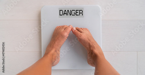 Fotografie Unhealthy weight woman weighting herself on bathroom scale