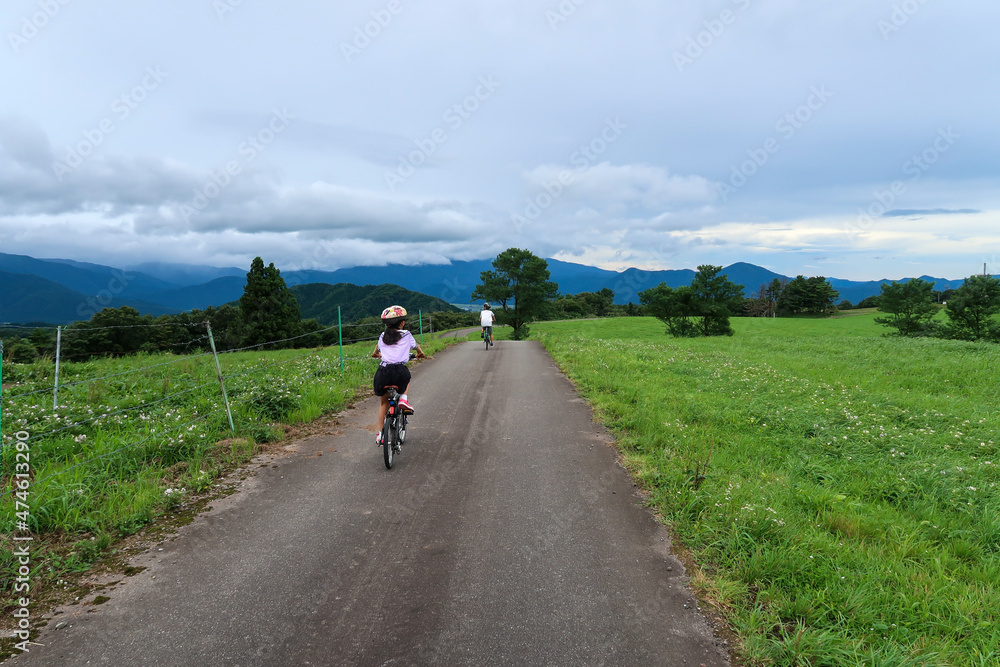 日本の田舎道をサイクリングする子供 日本の田舎道をサイクリングする子供