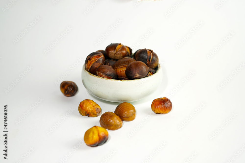 Obraz premium roasted chestnuts on a white background, winter