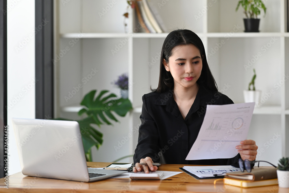 Successful businesswoman analyzing financial reports at her workplace. Successful businesswoman analyzing financial reports at her workplace.