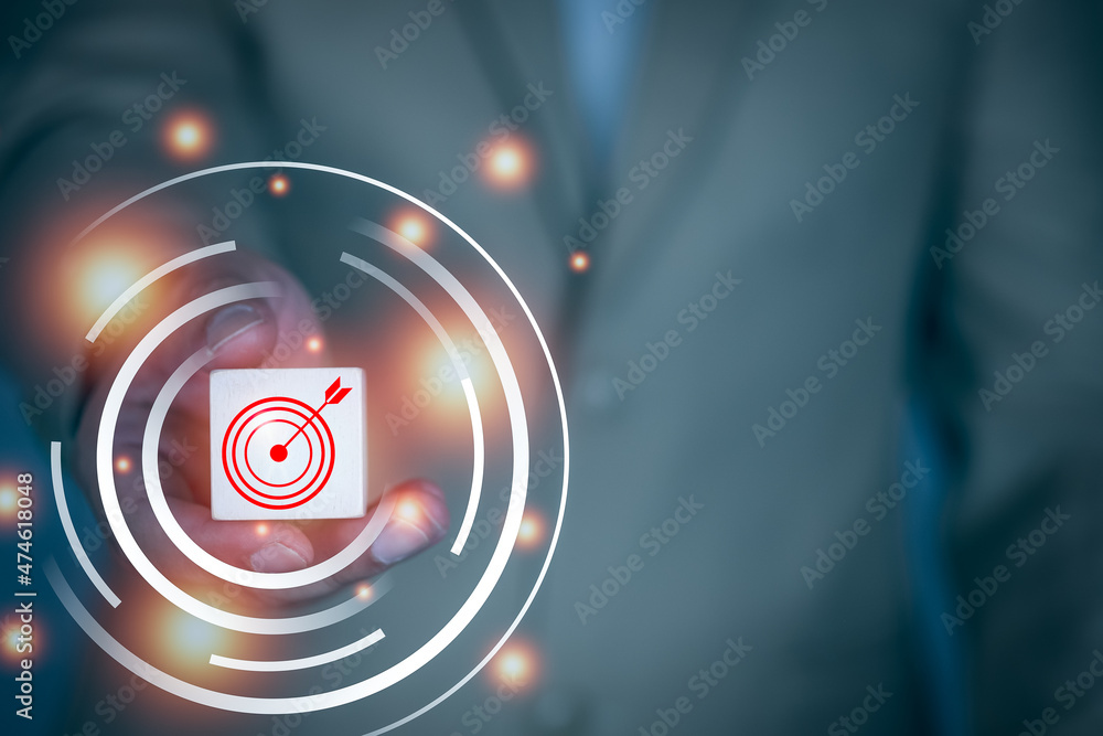 Business man holding wood block with a red circle being the target. Business man holding wood block with a red circle being the target.