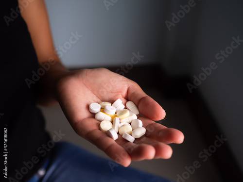 Drug on palm woman on dark black background. life Problems,Stress, Overdose, Addicted to Sleeping Pills, Narcotics, poor Health concept.