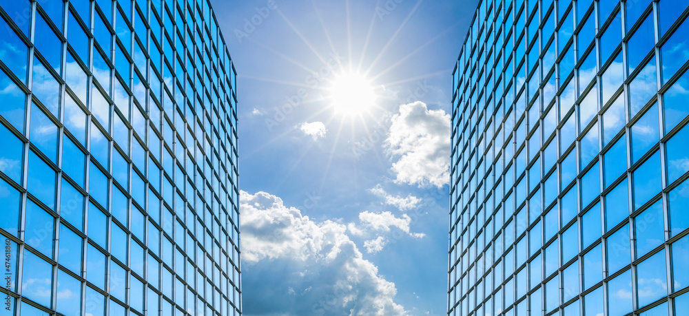 Modern office building with glass facade on a clear sky background. Transparent glass wall of office building. Modern office building with glass facade on a clear sky background. Transparent glass wall of office building.