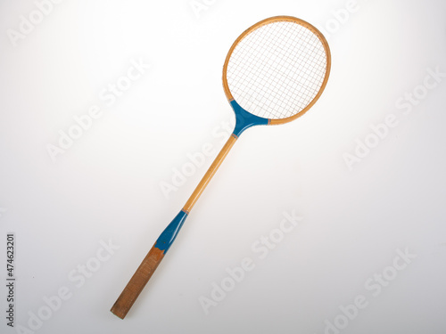 Old wooden blue badminton racket on grey background