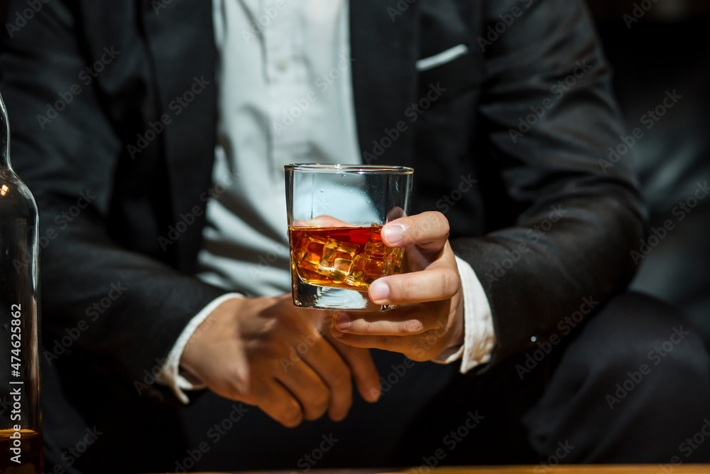 Closeup businessmen holding a glass of whiskey Closeup businessmen holding a glass of whiskey