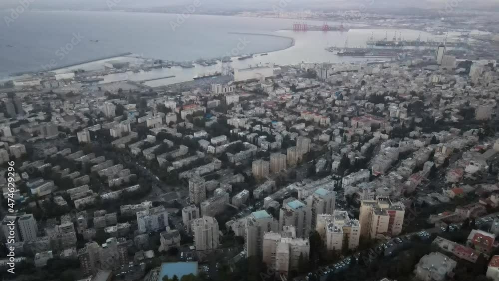 Quiet city with symmetrical buildings in the evening, with a port with cargo ships, Israel, Haifa Quiet city with symmetrical buildings in the evening, with a port with cargo ships, Israel, Haifa