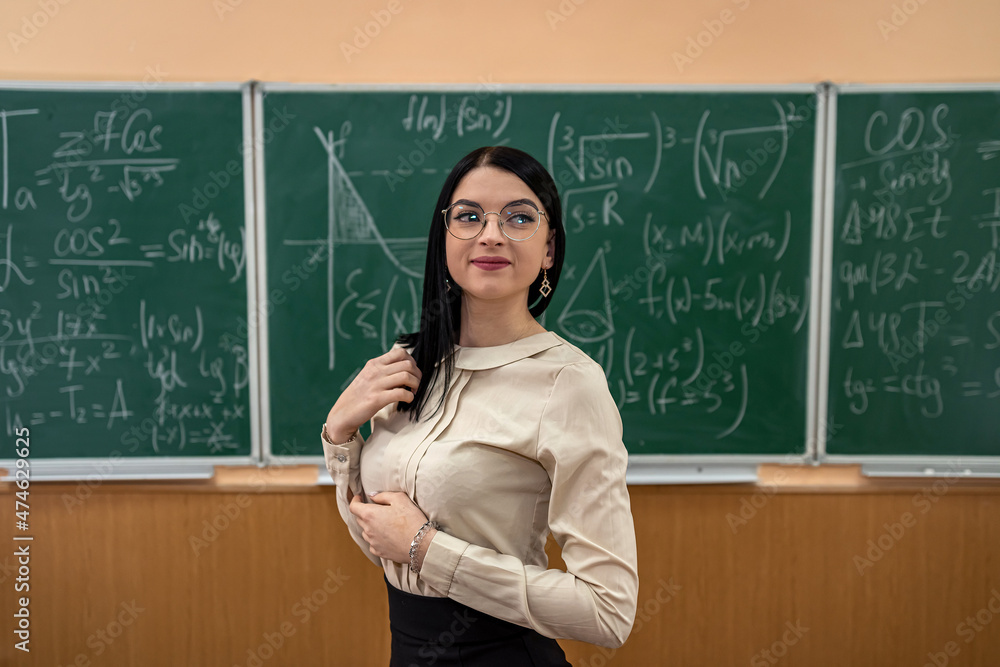 teacher explain completing mathematical equations on chalkboard in classroom teacher explain completing mathematical equations on chalkboard in classroom
