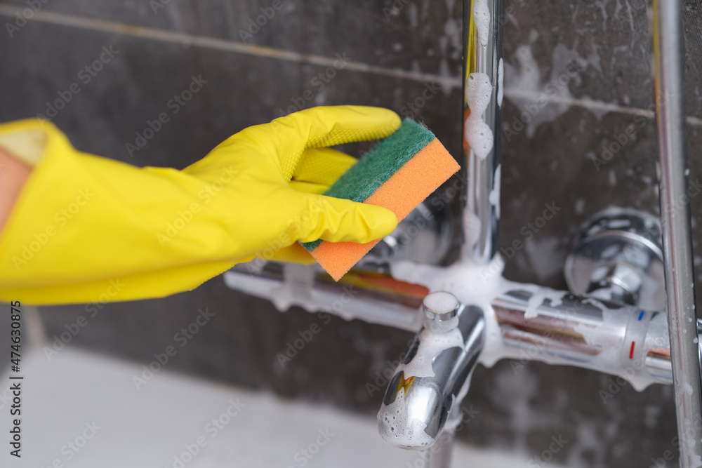 A hand in a glove washes the mixer with a sponge A hand in a glove washes the mixer with a sponge