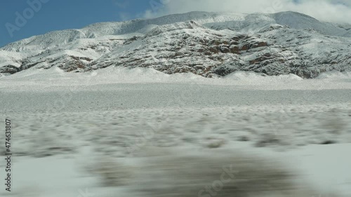 Road trip to Death Valley, driving auto, snow in California, USA. Hitchhiking winter traveling in America. Highway, mountain pass and dry barren wilderness. Passenger POV from car. Journey to Nevada. photo