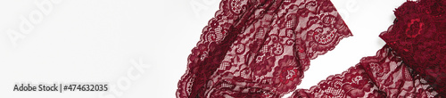 Creative sewing background, top view. Red, burgundy lace fabric. luxury cloth or liquid wave