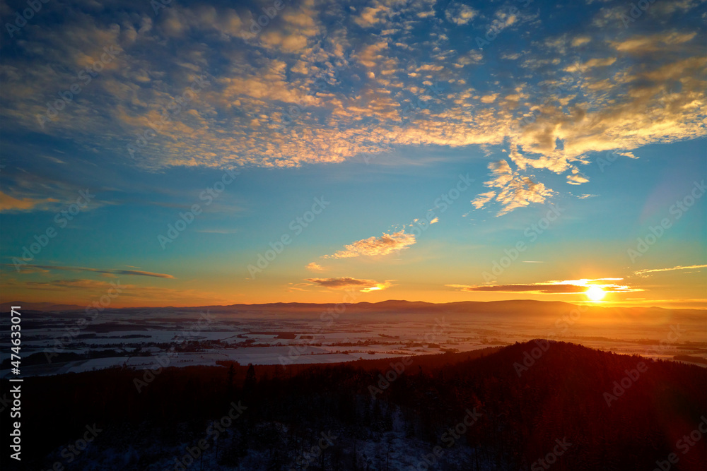 Obraz premium Sunset over mountans with forest covered with snow, beautiful winter landscape, nature background