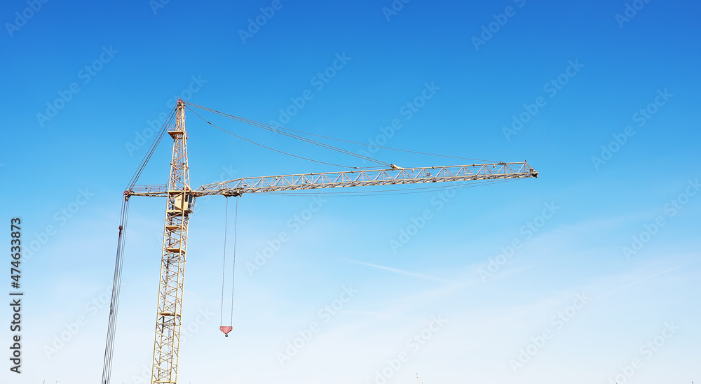 Construction crane on the background of the sky. Construction site.