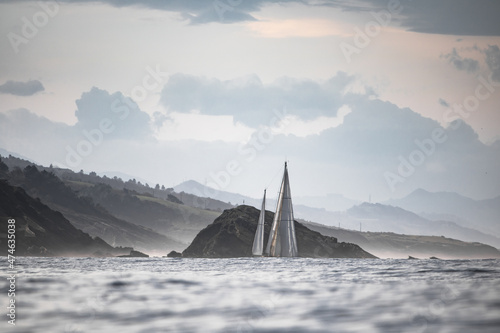 isolated sailing boat cruising on atlantic ocean beside ile des cochons, basque country, france, creative background