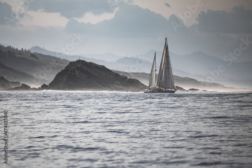 isolated sailing boat cruising on atlantic ocean beside ile des cochons, basque country, france, creative background