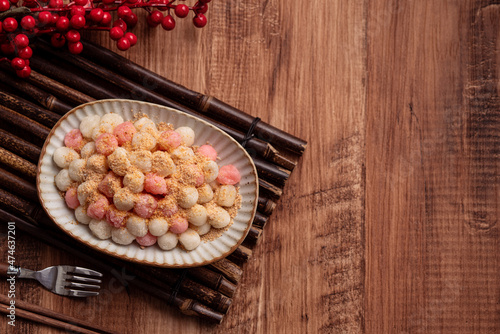 Deep-fried red and white tangyuan with peanut powder. photo