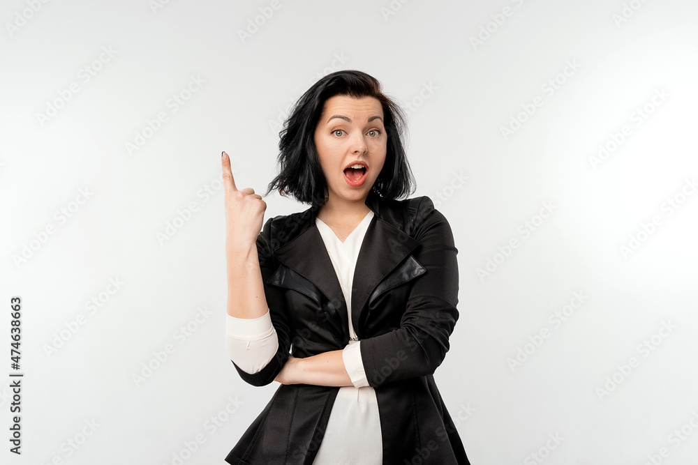 Pretty woman looking surprised, pointing finger up copy space, presenting your product, recommend follow link, click on banner, standing over white background Pretty woman looking surprised, pointing finger up copy space, presenting your product, recommend follow link, click on banner, standing over white background