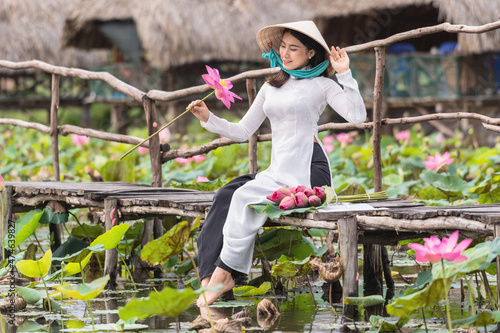 Fotografie, Obraz Portrait of beautiful vietnamese woman with traditional vietnam hat holding the