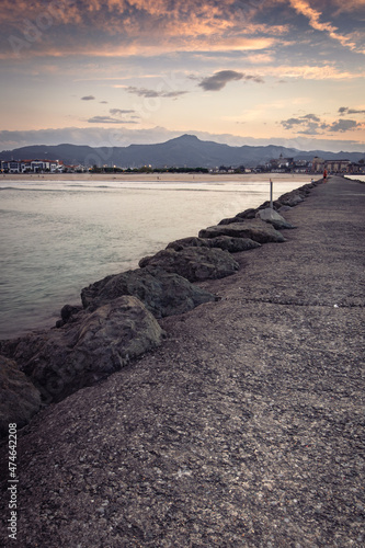 Scenic view on Hendaye beach from breakwater in sunset wintertime