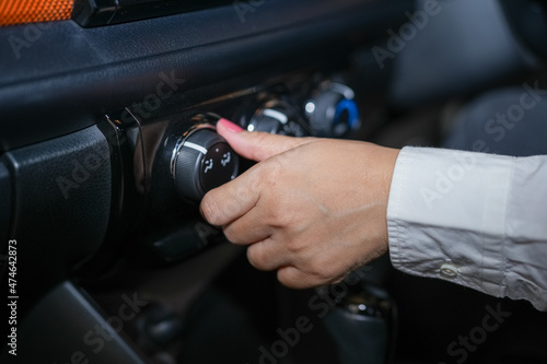 Selective focus, Woman's hand adjusting the cooling level in the car cabin to save energy. © Juraiwan