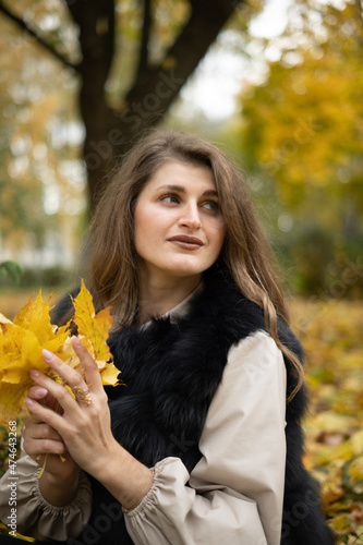girl model holding yellow leaves in her hand. photo session of the girl in the autumn park. 