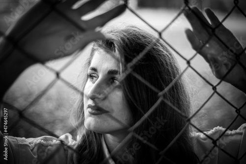 model girl behind the fence looking away. model out of focus.